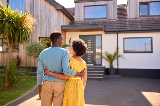 couple standing in front of home